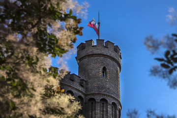 Kórnik, Wielkopolska / Poland - July 8th 2018: Tower of a castle near Poznań with polish flag on...