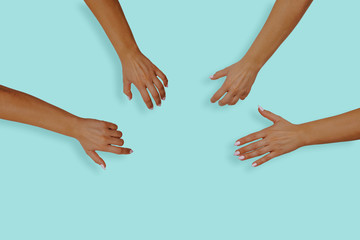 Top view of female hands with nails on a blue, pastel background. Female hands reach for something...