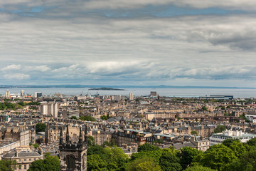 Edinburgh, Scotland, UK - June 13, 2012: Looking from Calton Hill over densely built Leith suburb towards the Nord Sea inlet under a heavy cloudscape. Island and other side of water.