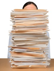 Young overworked manager at workplace with stacks of documents