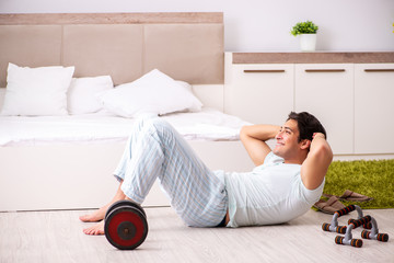 Young man doing morning routine in bedroom