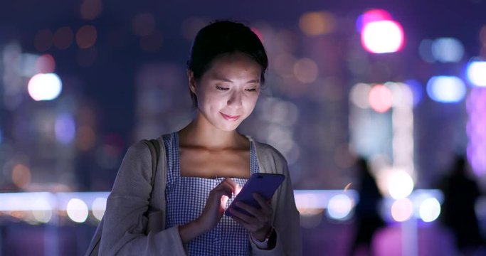 Woman look at smart phone at night