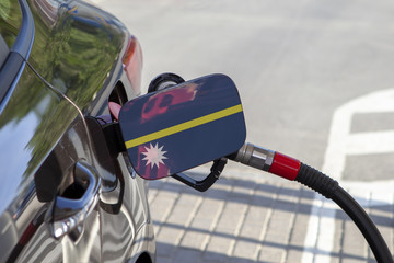Fueling car with petrol pump at a gas station.