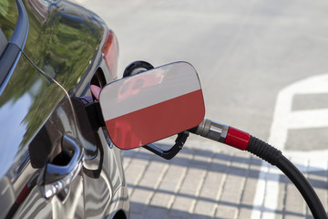 Fueling car with petrol pump at a gas station.