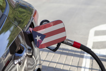 Fueling car with petrol pump at a gas station.