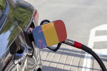 Fueling car with petrol pump at a gas station.