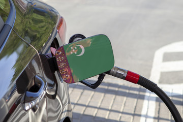 Fueling car with petrol pump at a gas station.