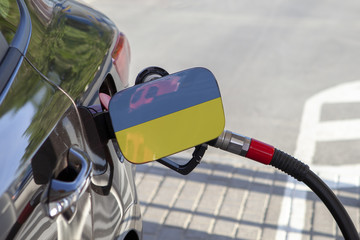 Fueling car with petrol pump at a gas station.