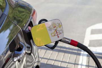 Fueling car with petrol pump at a gas station.