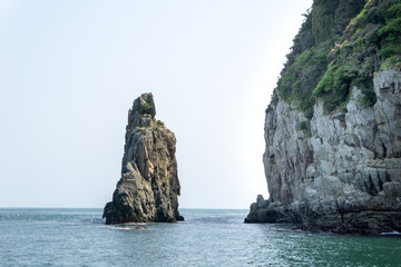 Naklejka premium Stone pillar emerged from the sea is the part of Geoje Haegeumgang rock islands in the Hanryeo marine national Park, Geoje City, South Korea.