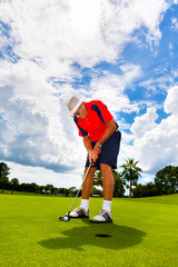 Senior man putting on the green