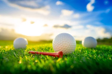  close up the golf ball and red tee pegs on the green background with sunset © lamyai