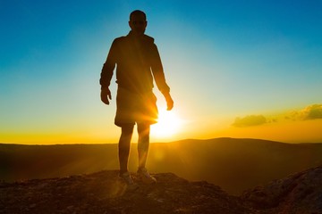 Man Standing on Rock Against Sun