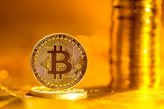 Bitcoin cryptocurrency coin with on a bright gold background