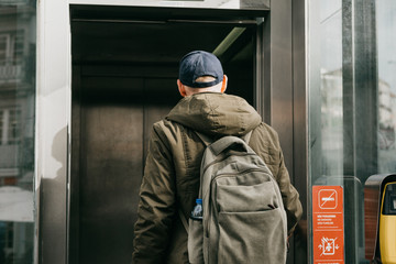 A tourist man with a backpack uses a street elevator in Porto in Portugal to go down to the metro. © franz12