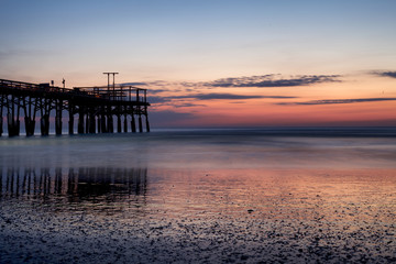Fototapeta na wymiar Early sunrise at the pier in Cocoa Beach, Florida
