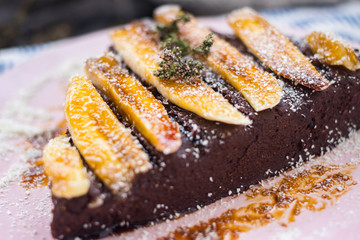 Vegan sweet cake. Raw chocolate pie. Vegetarian tart piece with bananas, maple syrup, dates, coconut and dark cocoa powder. Delicious and healthy breakfast or dessert.