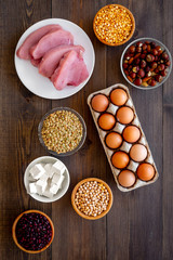 Healthy food. Products rich protein and fiber. Legumes, nuts, low-fat cheese, meet, eggs. Raw beans, chickpeas, lentil, almond, hazelnut on dark wooden background top view