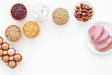 Healthy food. Products rich protein and fiber. Legumes, nuts, low-fat cheese, meet, eggs. Raw beans, chickpeas, lentil, almond, hazelnut on white background top view copy space