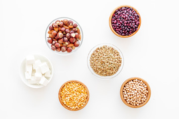Vegan protein source. Legumes, nuts, cheese. Raw beans, chickpeas, lentil, almond, hazelnut on white background top view
