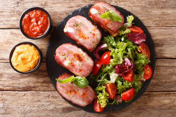 Grilled pork brisket and fresh salad are served ketchup and mustard. horizontal top view