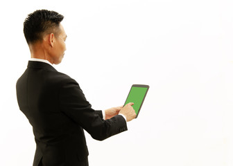 Asian Business man using tablet with green screen on white backgrounds backside views. Place for you text