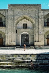 Bukhara / Uzbekistan - MAY 5 2010: boys playing near the ancient wells and water reserves in the...