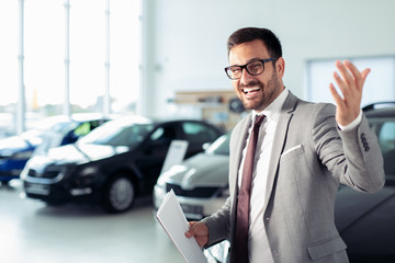 Fototapeta na wymiar Salesperson at car dealership selling vehicles
