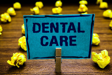 Naklejka premium Word writing text Dental Care. Business concept for maintenance of healthy teeth or to keep it clean for future Clothespin holding blue paper note crumpled papers several tries mistakes.