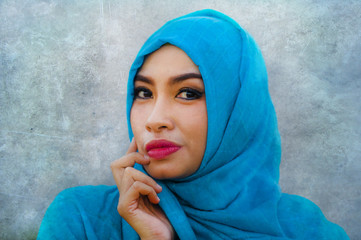 lifestyle isolated portrait of young beautiful and happy Asian woman smiling covered by muslim...