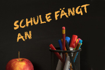 Ein Apfel, verschiedene Stifte und Schulanfang