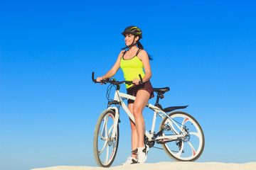 Fototapeta na wymiar Woman on a bicycle against the blue sky