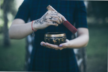 singing bowl  in woman  hands with indian henna