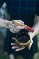 woman hands with henna keep singing bowl