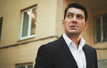 Handsome man in suit smoking cigarette