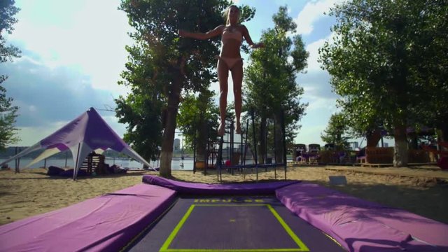 Woman Having Fun on trampoline at the Beach