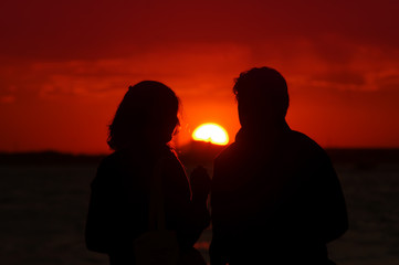 couple of man and woman watching beautiful sunset