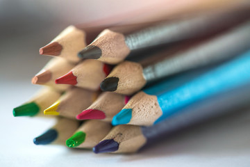 Obraz premium Pile of sharp coloured drawing pencils on table. Rainbow colors red, yellow, blue, green, purple. Concept of art, crafts and kids having fun