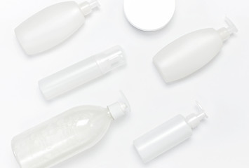 Cosmetic bottle containers on white background flat lay top view. Blank label for branding mock-up. Natural beauty product concept. Shower gel, shampoo, liquid soap without labels.