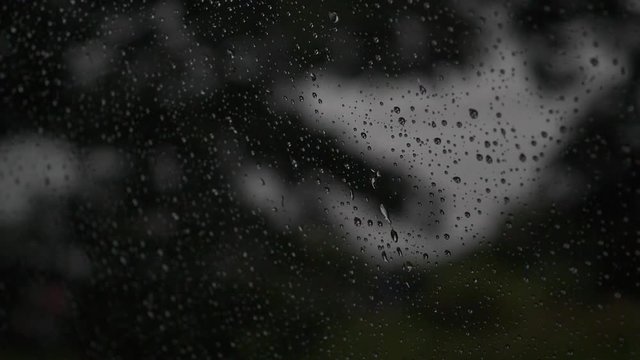 slow motion, rain drops on window car with driving on dark road