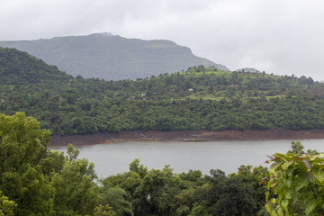 Fototapeta na wymiar Village surrounded by greenery mountains, hills, mountains, Maharashtra, India