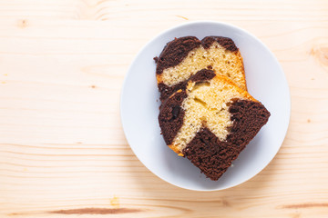 Homemade butter cake two tone chocolate and vanilla in white dish on wooden board with copy space