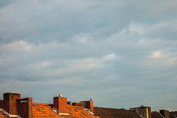 Roofs with chimneys and dramatic sky