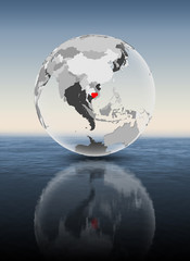 Cambodia on translucent globe above water