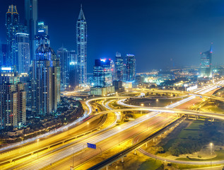 Fototapeta na wymiar Scenic nighttime skyline of big modern city with illuminated skyscrapers. Aerial view of Dubai Marina, UAE. Multicolored travel background.