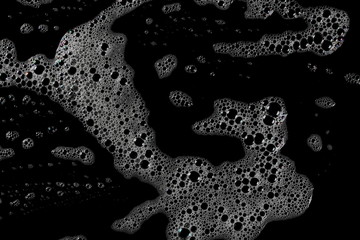 Soap foam with bubbles isolated on black background, with clipping path texture, top view - obrazy, fototapety, plakaty