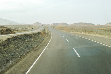 An asphalt road in the desert overlooking the hills. North Peru