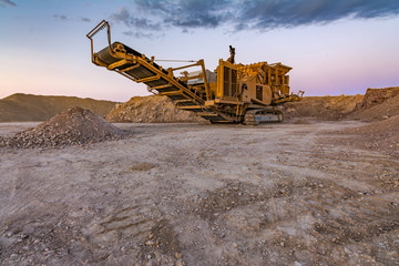 Stone crusher machine in a quarry or open-pit mine, to transform into gravel