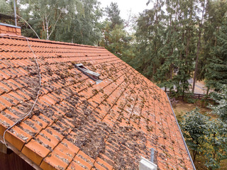 Inspection of the red tiled roof of a single-family house, inspection of the condition of the tiles on one roof side