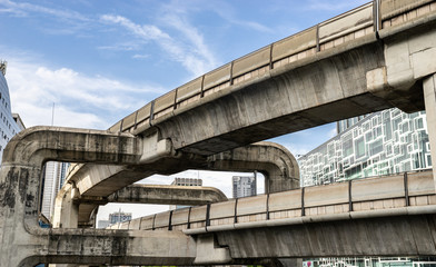 Fototapeta premium sky train railway bridge against sky and modern tower in Bangkok, Thailand : 03/08/18